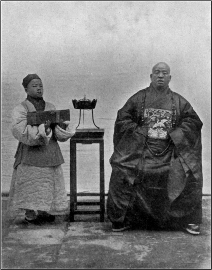 Buddhist Priest and Acolyte holding Book.